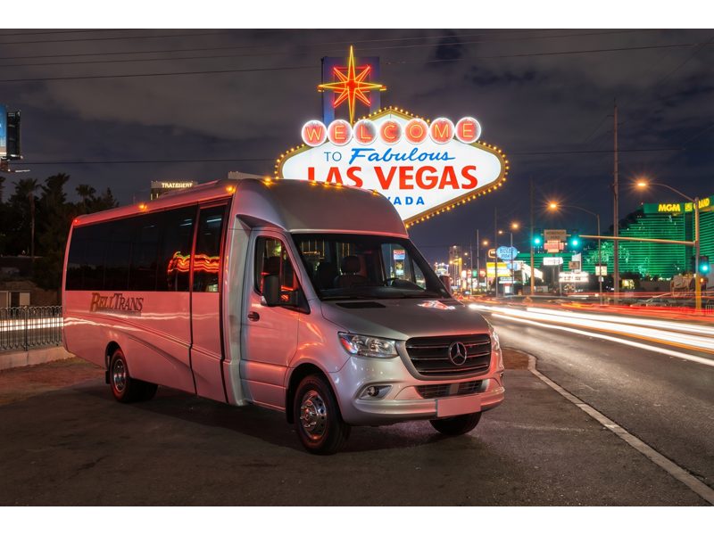 AIRPORT SHUTTLE Share-A-Ride Transfer - Bell Trans shuttle parked beneath the iconic Welcome to Fabulous Las Vegas sign.