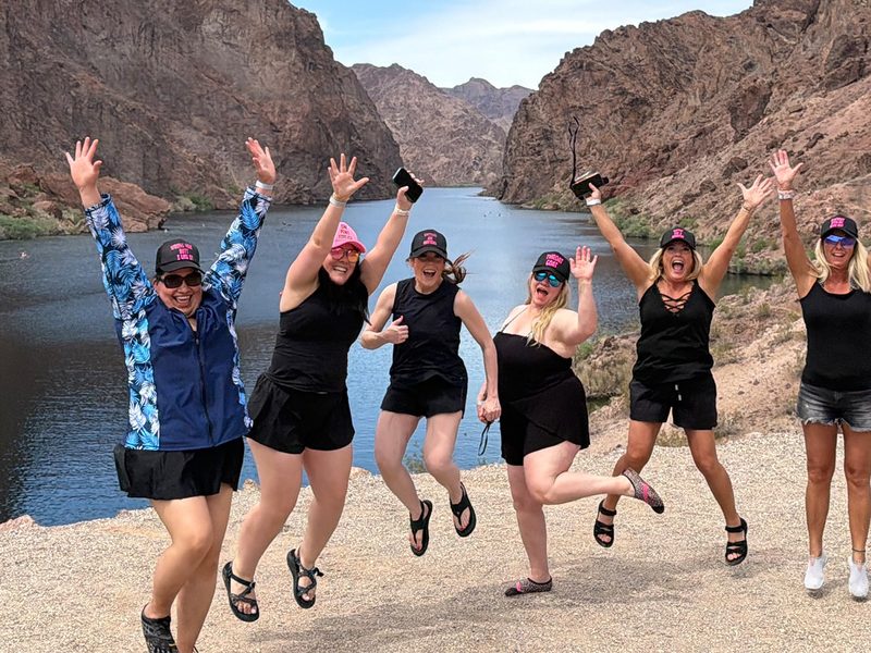 Black Canyon Kayak Tour - Friends celebrate above the river with sweeping Black Canyon scenery stretching behind them.