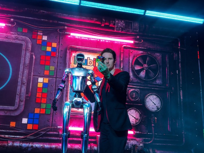HACKED - Keelan Leyser performs sleight of hand beside a humanoid robot in HACKED’s neon-lit Las Vegas production.