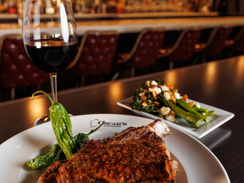 Oscar's Steakhouse signature bone-in ribeye, expertly prepared and served with classic steakhouse sides.