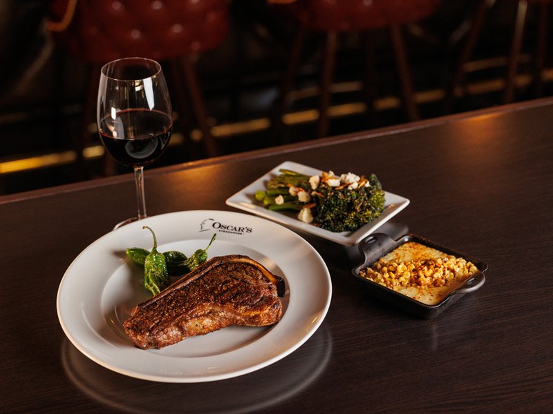 Kansas City dry-aged steak paired with signature accompaniments at the iconic Oscar's Steakhouse.