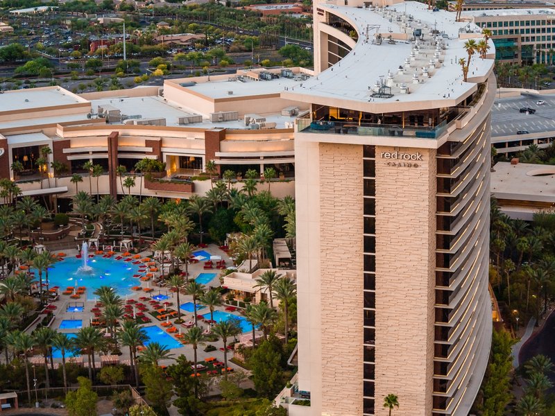 An aerial view showcases Red Rock Casino Resort & Spa, its hotel tower and the expansive pool complex below.