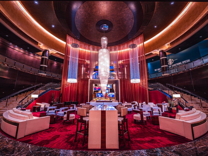 The Lobby Bar makes a dramatic centerpiece with soaring crystal fixtures, rich red accents and inviting lounge seating.