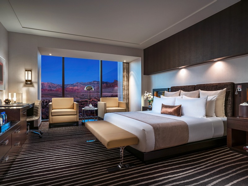 A luxury king guest room pairs contemporary comfort with sweeping canyon and mountain views beyond the floor-to-ceiling windows.
