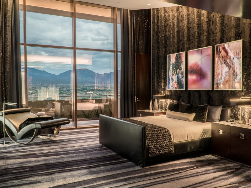 One80 delivers a sleek, residential-style bedroom framed by panoramic windows and sophisticated textures throughout the space.