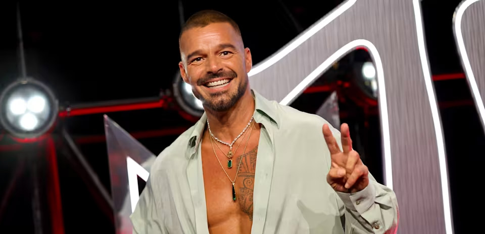 Latin pop star performing under stage lights at a Las Vegas theater
