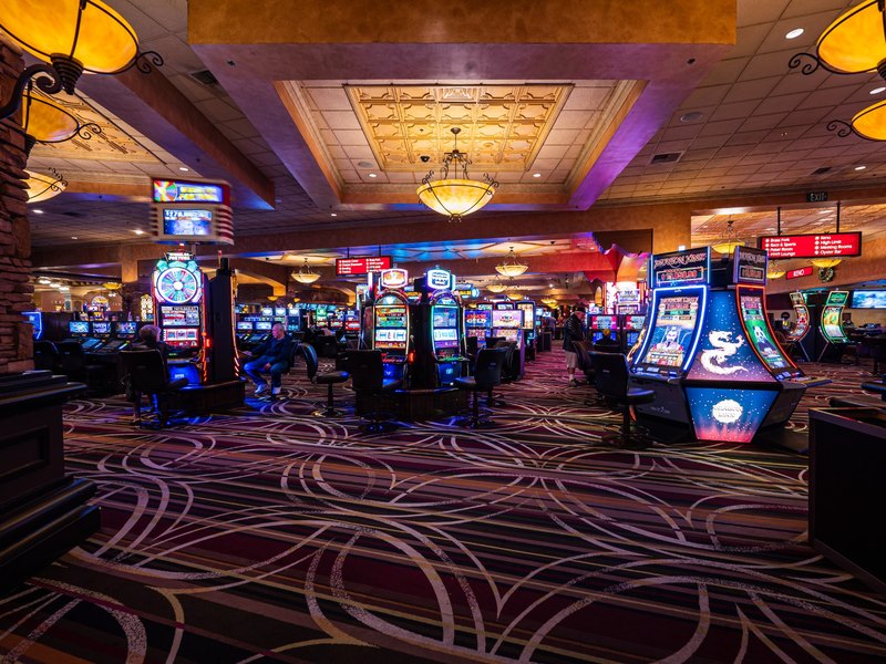 The Santa Fe Station casino offers a colorful mix of slot machines arranged across a spacious, warmly lit gaming floor.