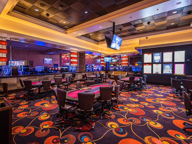 The poker area combines table seating, nearby video poker and warm ambient lighting for a relaxed casino atmosphere.