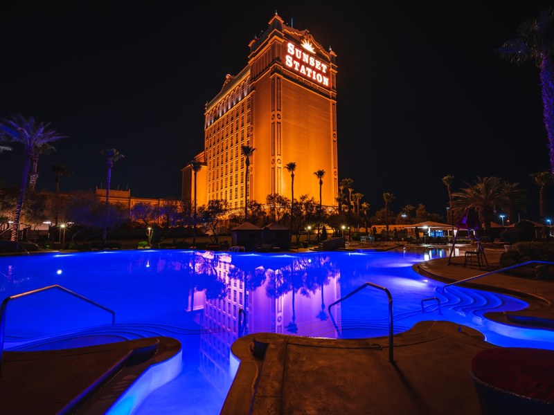 The resort tower rises above Sunset Station’s blue-lit pool, offering a dramatic nighttime view of this Henderson casino hotel.