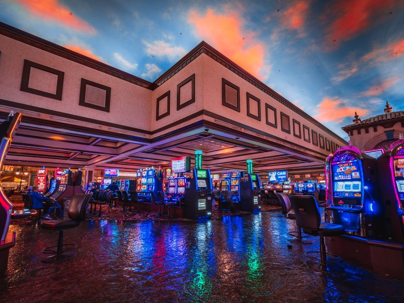 Colorful slot machines fill the casino beneath Sunset Station’s distinctive sky-inspired ceiling, creating a lively gaming atmosphere.