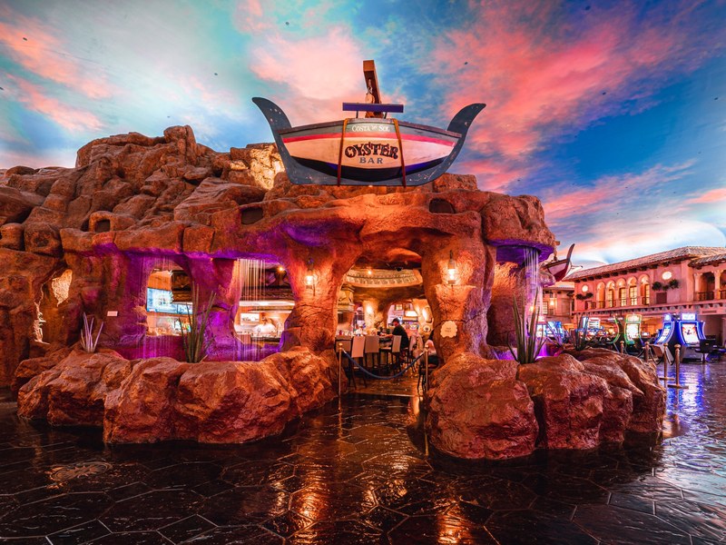 The Oyster Bar is tucked into a playful rock grotto, bringing a colorful coastal-inspired setting to Sunset Station’s casino floor.