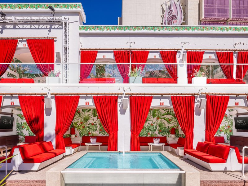 Private spa bungalows offer shaded seating, plush furnishings, and an elevated poolside retreat.